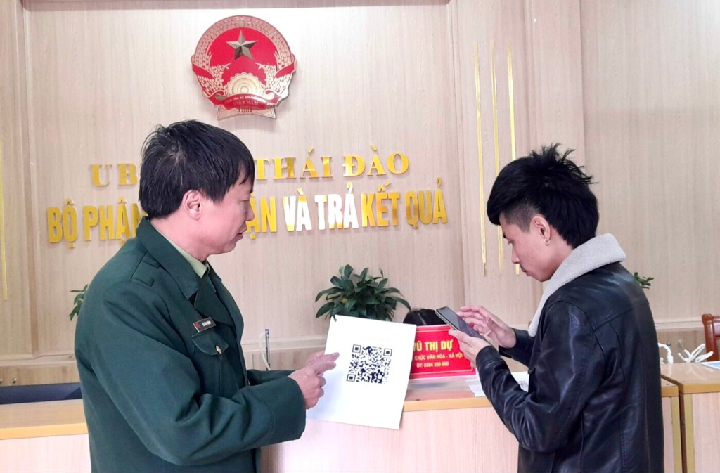 Hội CCB xã Thái Đào hướng dẫn công dân quét mã QR tại bộ phận một cửa xã.